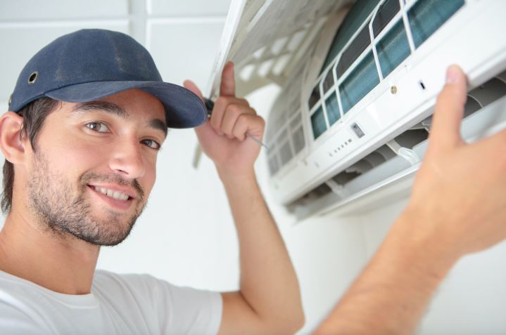 ac repair man fixing an air conditioning unit